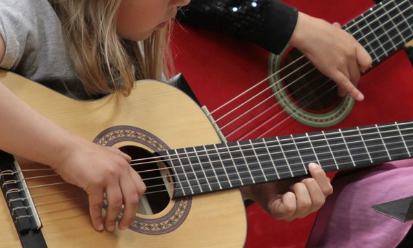 Närbild på gitarrspelande barn