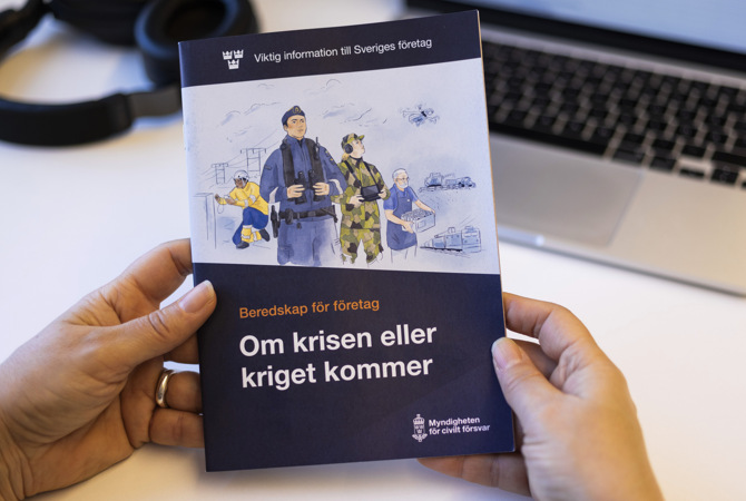 bild-pa-person-som-haller-i-broschyren-vid-skrivbord (3).jpg