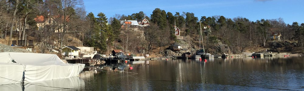 Förtöjda båtar, bryggor och hus längs Eols udde.