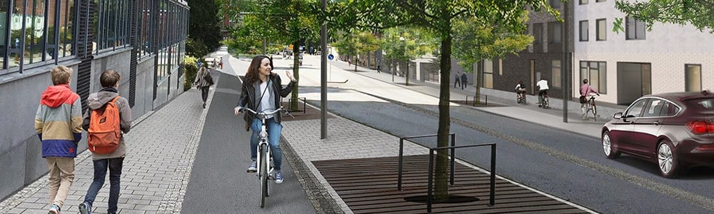 En trottoar med människor som promenerar och en cykelbana längs med en stadsgata.