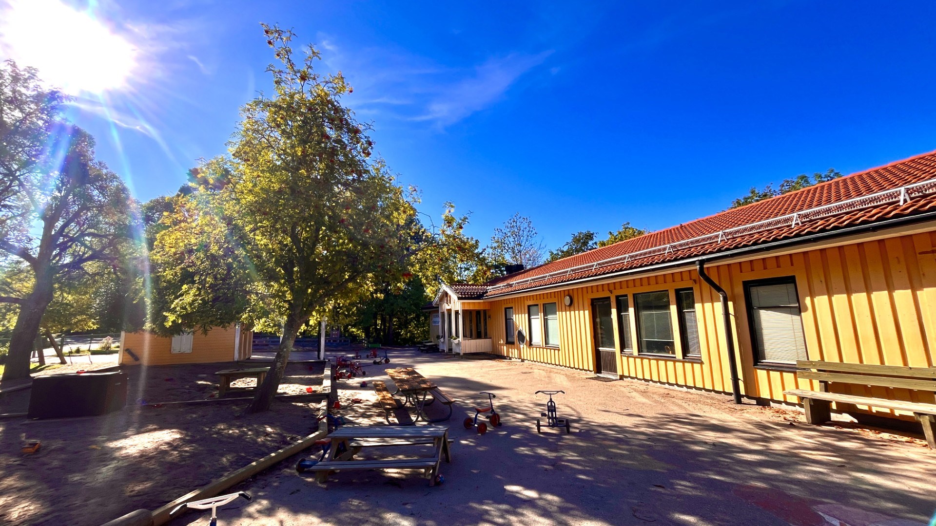Förskolegård med gul träfasad.