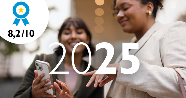 Foto på två unga tjejer som glatt umgås och tittar på något på en mobil