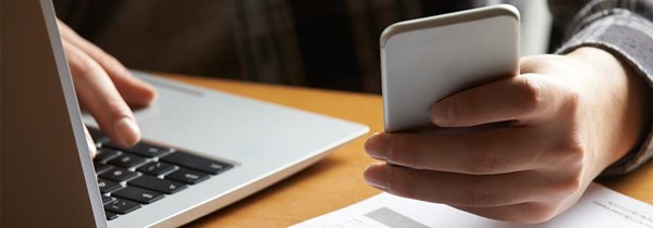 Kontorsplats med dator och mobiltelefon