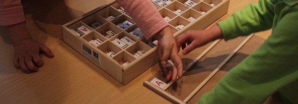barn som arbetar med bokstäver i trä