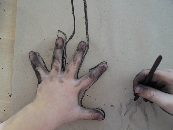 Händer som ritar med kol